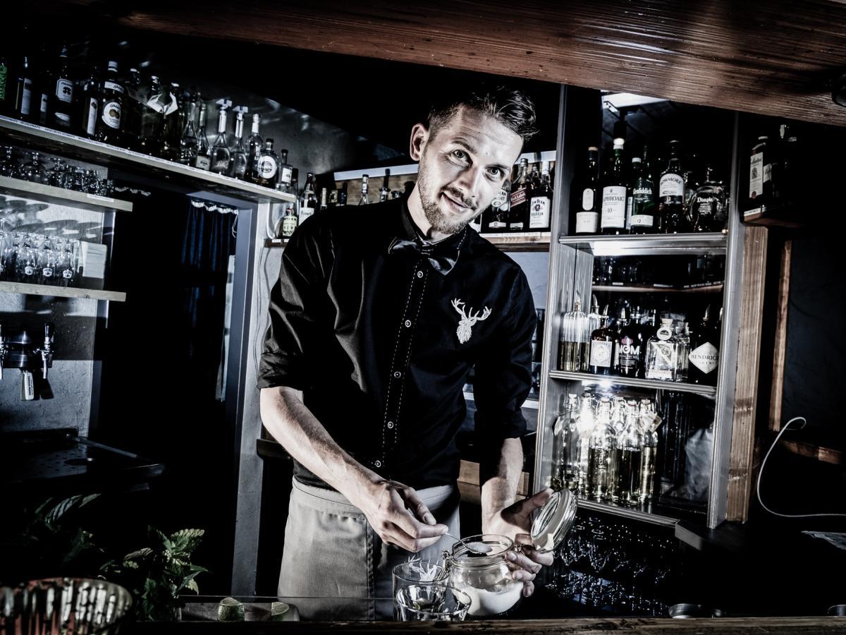 Das Bild zeigt den Barkeeper bei der Zubereitung von Getränken im Hotel Walserhof